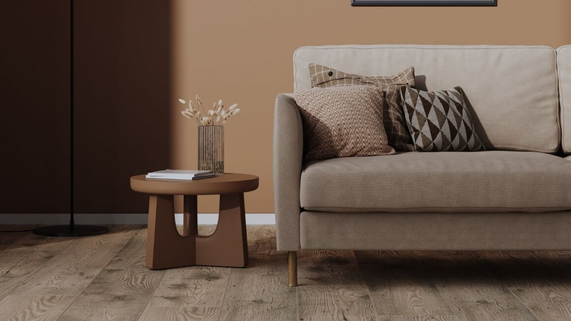 Cosy sofa next to a wooden table with a vase of dried flowers showcasing brown tones interior design